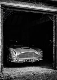 En klassisk Aston Martin DB5 stolt parkerad i ett nostalgiskt garage.-3