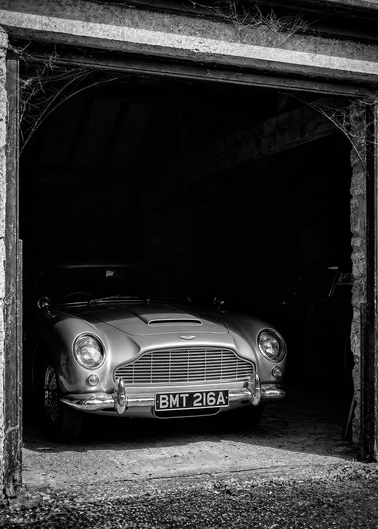 En klassisk Aston Martin DB5 stolt parkerad i ett nostalgiskt garage.-12