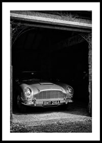 A classic Aston Martin DB5 proudly parked in a nostalgic garage.-0