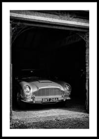 En klassisk Aston Martin DB5 stolt parkerad i ett nostalgiskt garage.-0