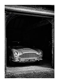 A classic Aston Martin DB5 proudly parked in a nostalgic garage.-1