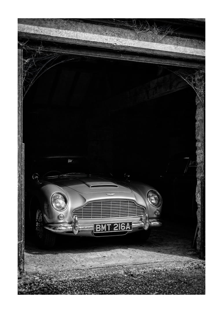 En klassisk Aston Martin DB5 stolt parkerad i ett nostalgiskt garage.-12