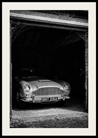 A classic Aston Martin DB5 proudly parked in a nostalgic garage.-2