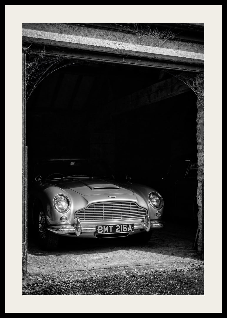 A classic Aston Martin DB5 proudly parked in a nostalgic garage.-12