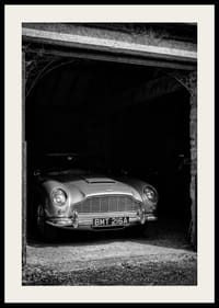 En klassisk Aston Martin DB5 stolt parkerad i ett nostalgiskt garage.-2