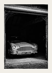 A classic Aston Martin DB5 proudly parked in a nostalgic garage.-3