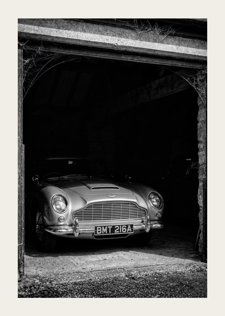 A classic Aston Martin DB5 proudly parked in a nostalgic garage.-12