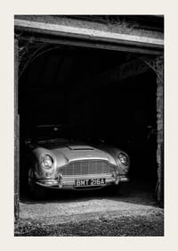En klassisk Aston Martin DB5 stolt parkerad i ett nostalgiskt garage.-3