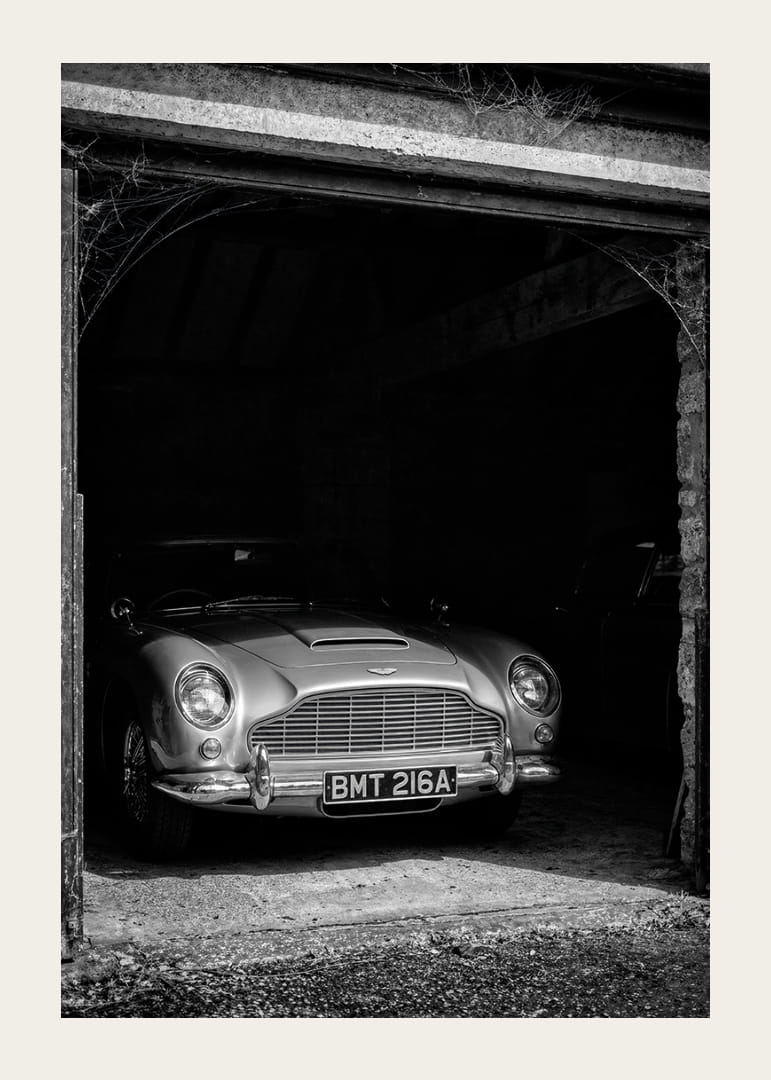 En klassisk Aston Martin DB5 stolt parkerad i ett nostalgiskt garage.-12