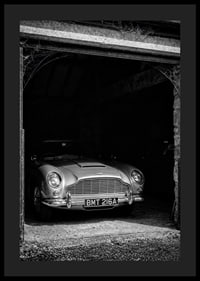 A classic Aston Martin DB5 proudly parked in a nostalgic garage.-4