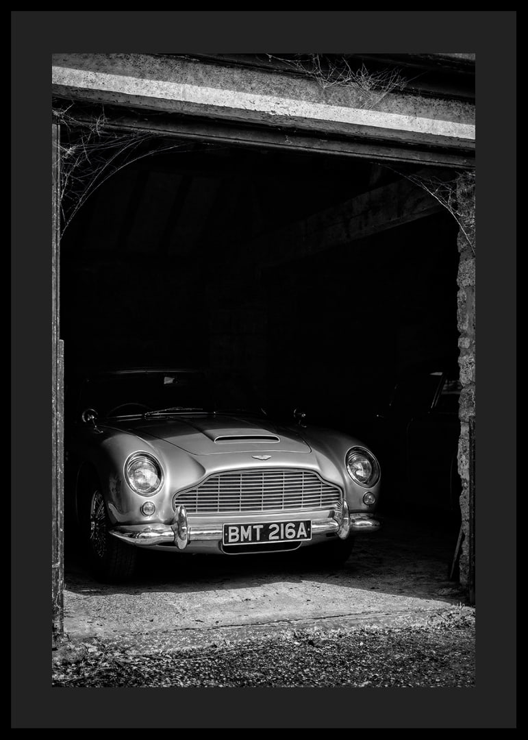 A classic Aston Martin DB5 proudly parked in a nostalgic garage.-12
