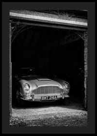 En klassisk Aston Martin DB5 stolt parkerad i ett nostalgiskt garage.-4