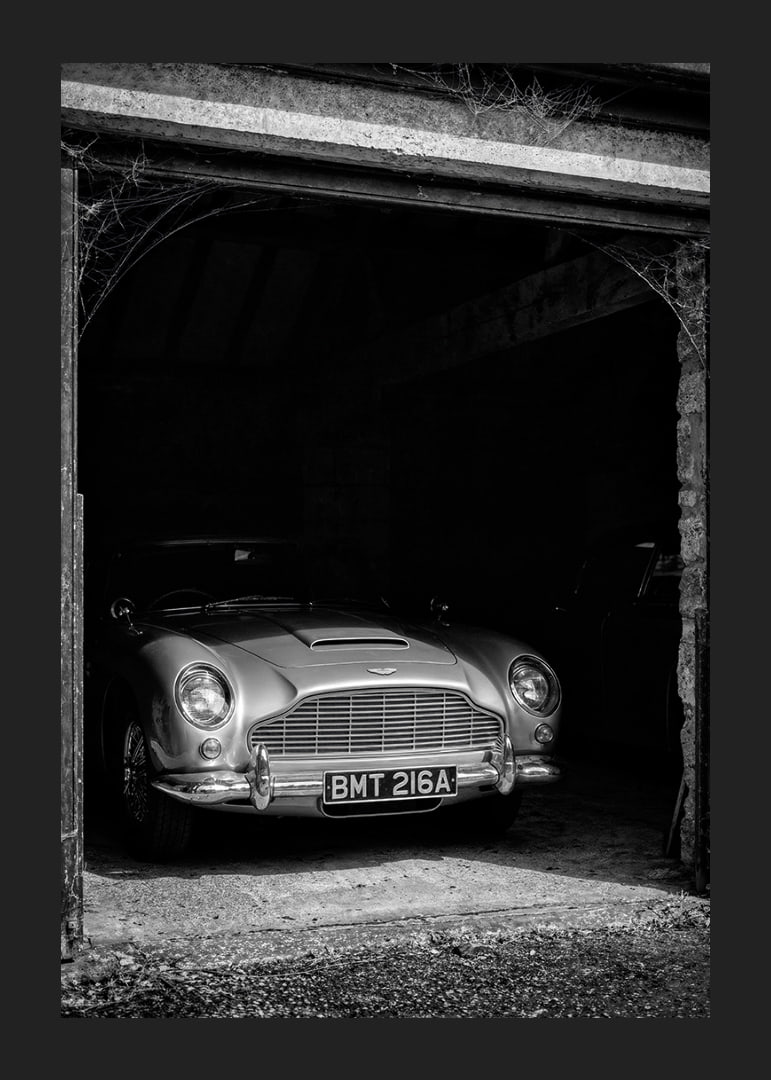 A classic Aston Martin DB5 proudly parked in a nostalgic garage.-12