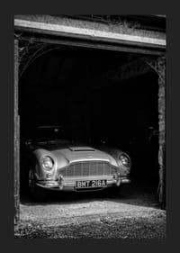 En klassisk Aston Martin DB5 stolt parkerad i ett nostalgiskt garage.-5