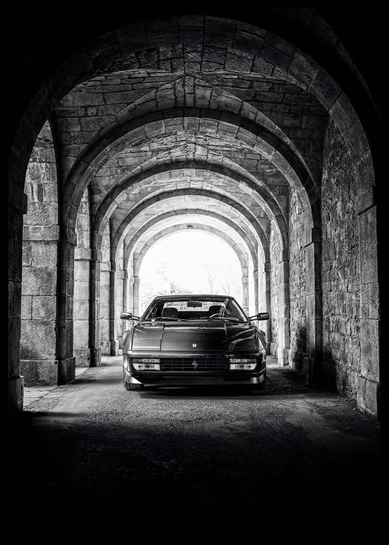 En klassisk Ferrari Testarossa genom en stentäckt valvpassage.-12