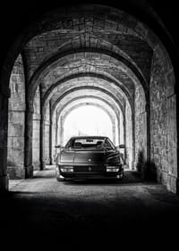 En klassisk Ferrari Testarossa genom en stentäckt valvpassage.-3