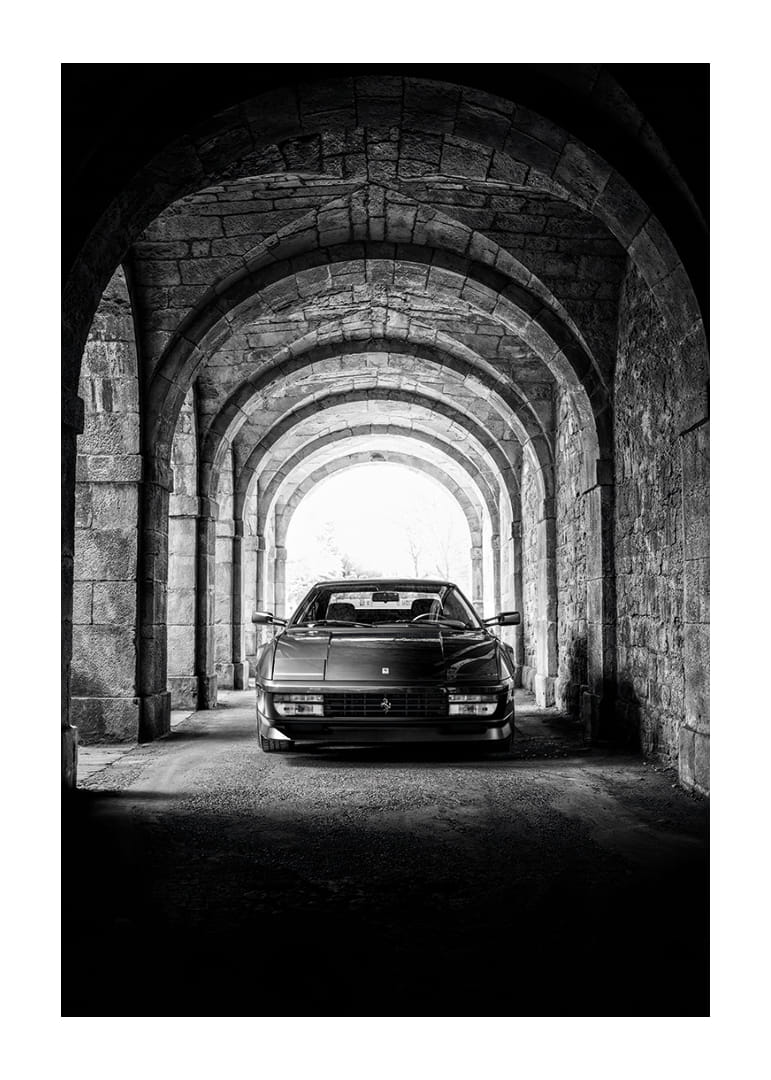 En klassisk Ferrari Testarossa genom en stentäckt valvpassage.-12