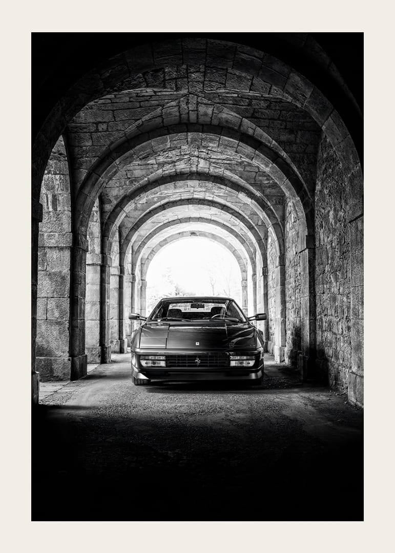 En klassisk Ferrari Testarossa genom en stentäckt valvpassage.-12