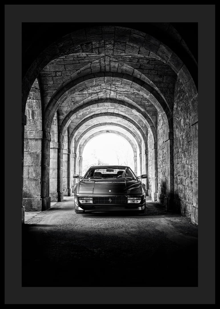 En klassisk Ferrari Testarossa genom en stentäckt valvpassage.-12