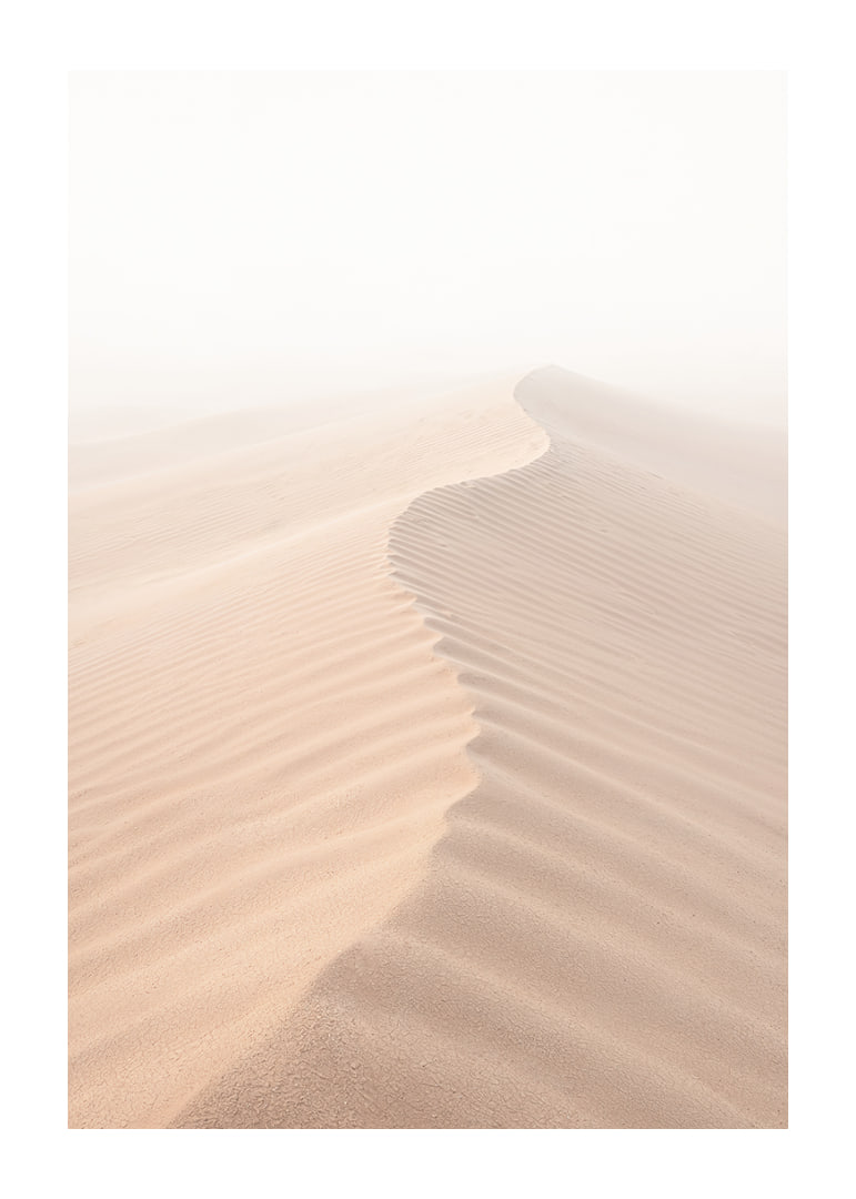 A soft wave of sand sweeps through a desolate landscape.-12