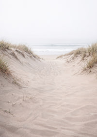 Soft sand leads towards the distant horizon of the sea.-7