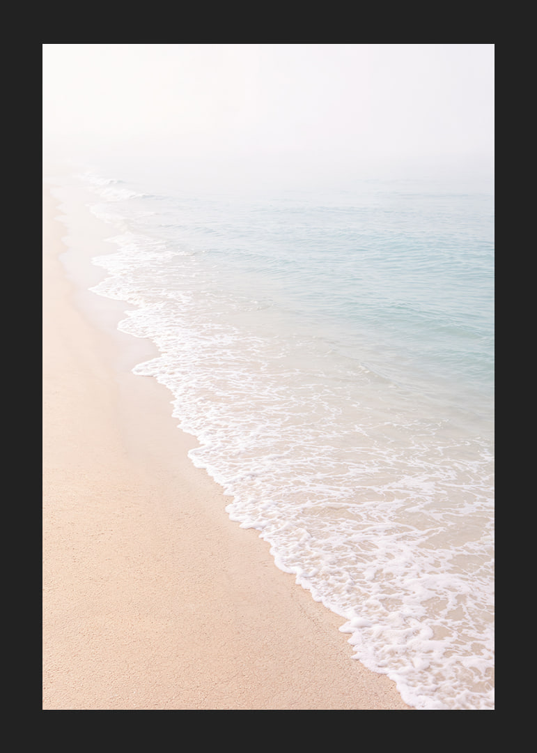 Gentle waves roll in towards the misty coast.-12