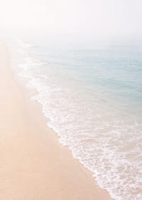 Gentle waves roll in towards the misty coast.-7