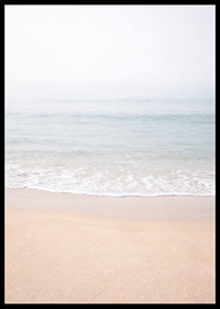 A misty coast where the sea meets the sand in soft tones.-6