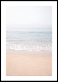 A misty coast where the sea meets the sand in soft tones.-0
