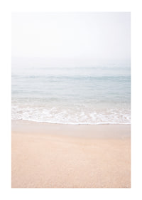 A misty coast where the sea meets the sand in soft tones.-1