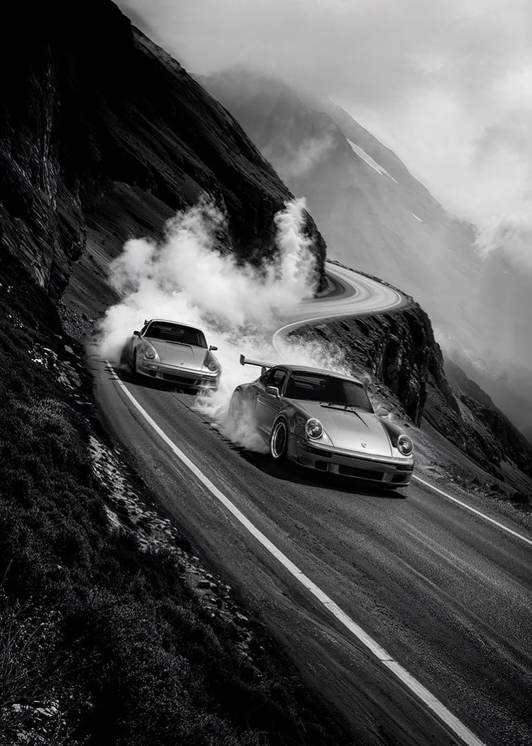 Två Porsche 911 driftar i en dimmig bergskurva-12