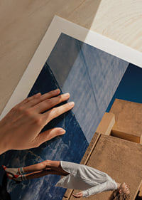 The woman floats against a contrasting wall under a clear blue sky.-9