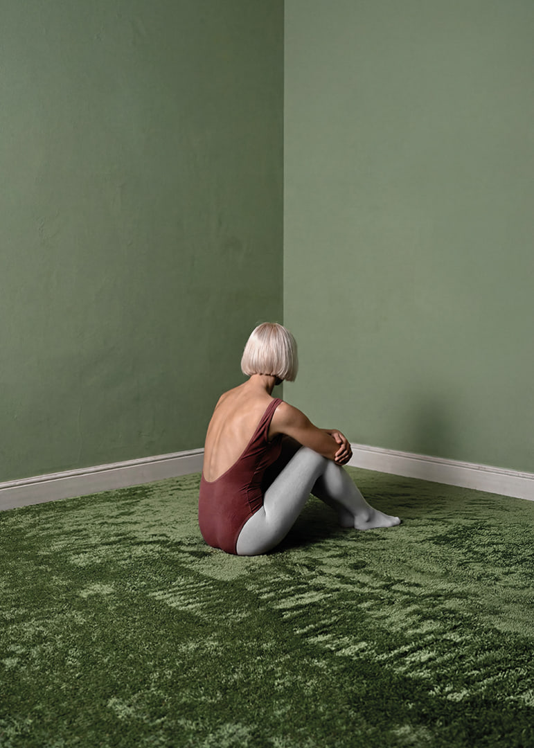 Eine Ballerina sitzt still in einem grünen, friedlichen Zimmer.-12