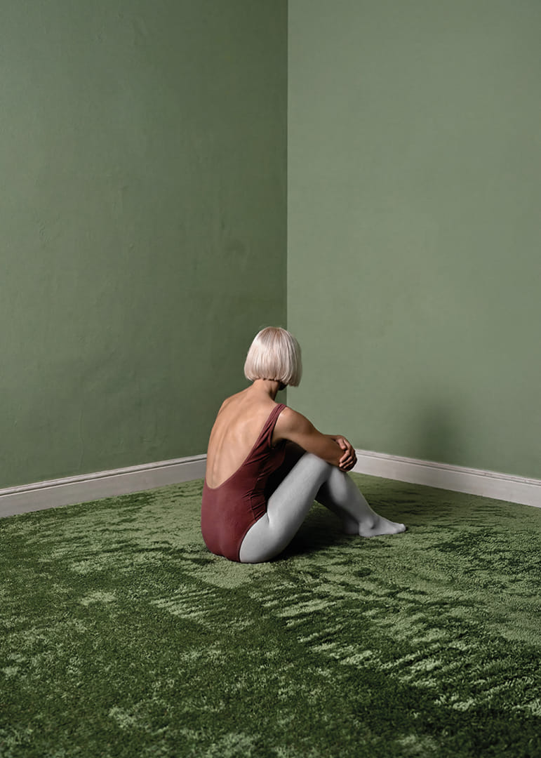 Une ballerine est assise tranquillement dans une pièce verte et paisible.-12