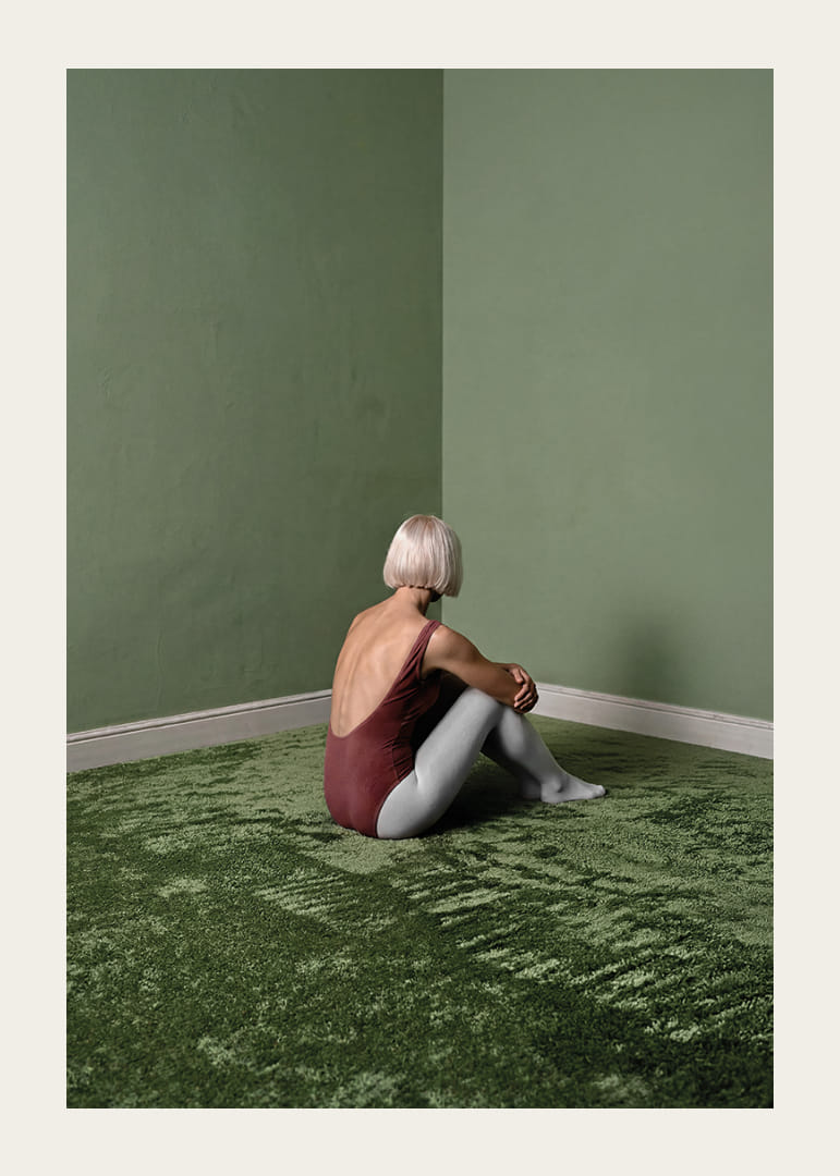 Une ballerine est assise tranquillement dans une pièce verte et paisible.-12