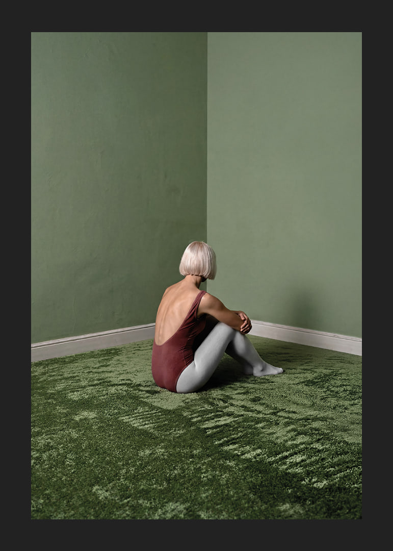 Eine Ballerina sitzt still in einem grünen, friedlichen Zimmer.-12