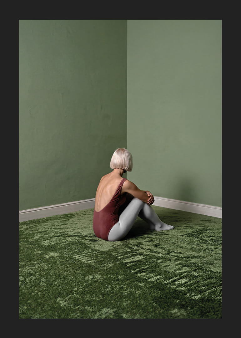Une ballerine est assise tranquillement dans une pièce verte et paisible.-12