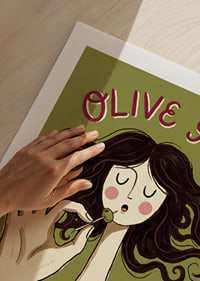 Une femme déguste une olive sur une affiche ludique.-9