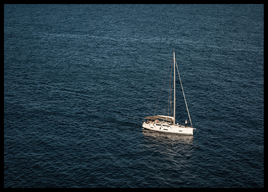 En segelbåt glider över det stilla, djupblå havet.-12