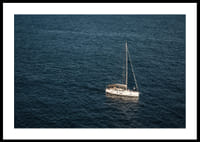 En segelbåt glider över det stilla, djupblå havet.-0