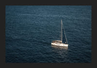 En segelbåt glider över det stilla, djupblå havet.-5