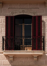 An elegant balcony with rustic red shutters.-7