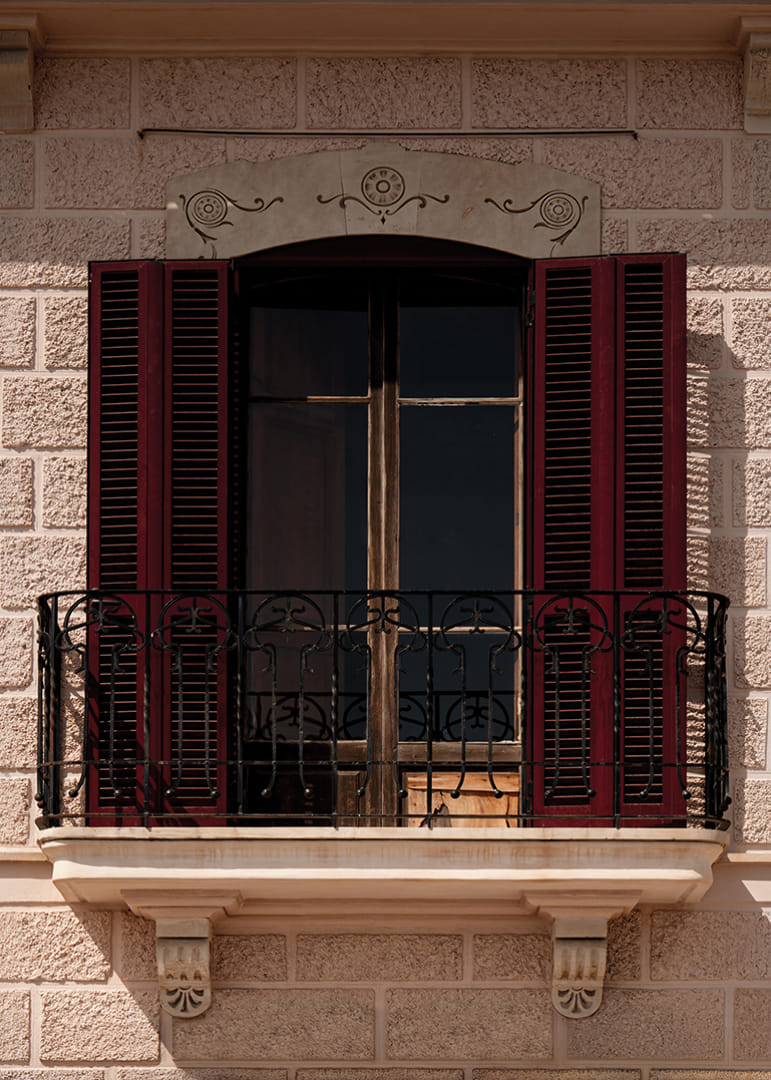 An elegant balcony with rustic red shutters.-12
