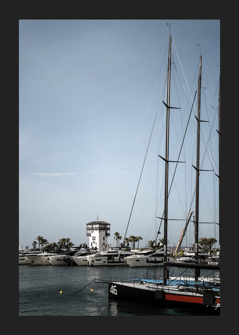 A quiet harbor with elegant masts against a clear sky.-12