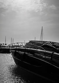 Silhouettes of boats in a calm water landscape.-7