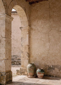Two rustic pots rest under a timeless stone arch.-7