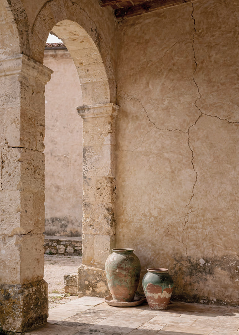 Two rustic pots rest under a timeless stone arch.-12