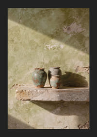 Tre vasi rustici appoggiati a un muro consumato dal tempo.-5