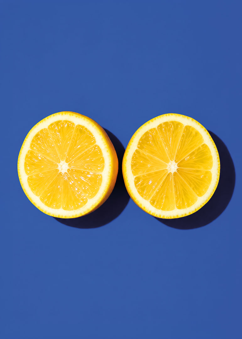 Two sunny yellow lemon halves shine against a deep blue background with fresh energy.-12