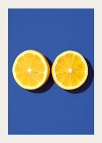 Two sunny yellow lemon halves shine against a deep blue background with fresh energy.-3